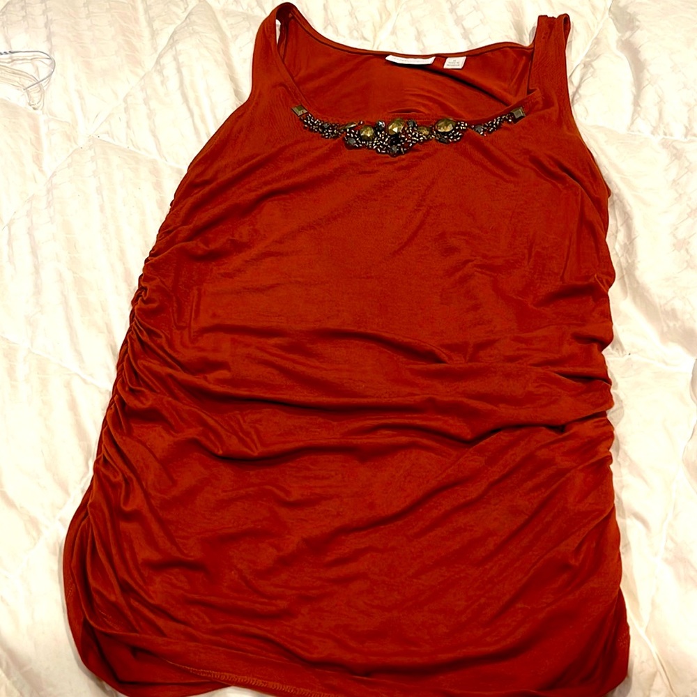 Burnt orange stretchy tank top with beaded embellishment at neckline.